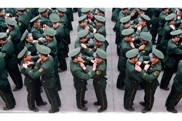 Des militaires se remettent des insignes lors d'une cérémonie dans une base militaire, au Sichuan.