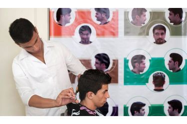 En Iran, les hommes et les femmes ne doivent pas se faire couper les cheveux n’importe comment. Le gouvernement iranien a établi une liste de coupes «acceptables». Derrière ce coiffeur et son client à Téhéran, une affiche rappelle quelles sont ces quelques coupes. 