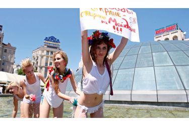 Des militantes de l&#039;organisation des droits des femmes &quot;Femen&quot; protestent dans une fontaine sur la place de l&#039;Indépendance dans le centre de Kiev (Ukraine). Ces femmes sont contre les coupures annuelles d&#039;eau chaude de la ville. En effet, chaque année pendant plusieurs semaines, l’approvisionnement en eau chaude est coupé pour permettre aux travailleurs de réparer les tuyaux et l&#039;équipement. &quot;Il n&#039;y a pas d&#039;eau dans le robinet, je fais ma lessive sur la place&quot;, peut on lire sur la pancarte.