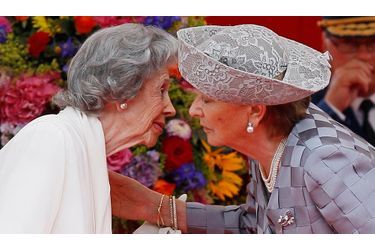 La reine Fabiola embrasse sa belle soeur, la reine Paola, pendant le défilé militaire de la fête nationale.