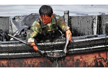 <br />
A Dalian, en Chine, un homme tente d’extraire le pétrole qui s’est déversé dans les eaux du port. Le 16 juillet dernier, l’explosion de deux oléoducs utilisés pour le déchargement d’un tanker ont engendré une marée noire. 