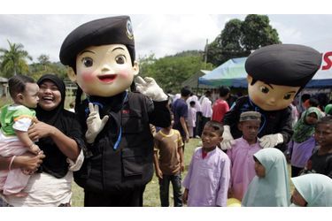 Les mascottes de l&#039;armée thaïlandaise, dont l&#039;objectif symbolique est de rendre les soldats familiers aux habitants de cette région trouble, jouent avec des enfants musulmans dans un village au sud de la province de Yala, le 17 juillet 2010.