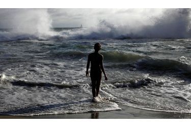 Une femme téméraire brave les vagues de Venice Beach à Los Angeles en Californie alors qu&#039;une tempête venant de l&#039;hémisphère sud fait rage.