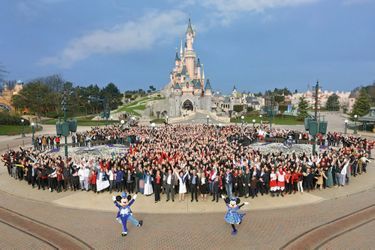 Derrière Mickey et Minnie, Catherine Powell (devant, en tailleur blanc), présidente d’Euro Disney, et un millier de salariés, mercredi 15 mars.