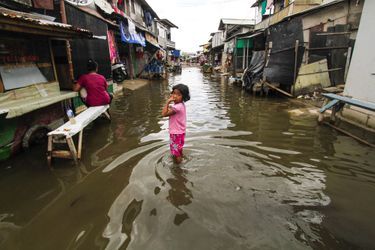 Une enfant les pieds dans l&#039;eau, qui a envahi Jakarta, en janvier 2018. 