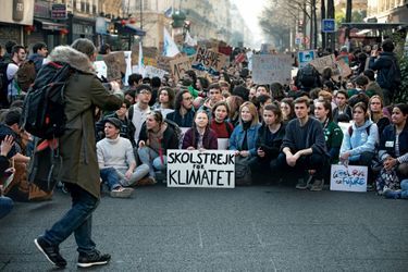 Avec sa pancarte « En grève pour le climat », Greta Thunberg en tête d’une manifestation de  jeunes à Paris, le 22 février. De dos : son père.