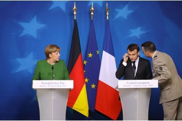 23 mars 2018. Lors d'une conférence de presse commune avec Angela Merkel à Bruxelles, Emmanuel Macron est informé par son aide de camp de l'évolution de l'attaque de Trèbes. 