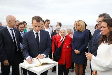 Au parc de la Mémoire, Emmanuel Macron laisse un mot dans le livre d'or.