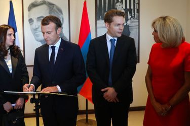 Emmanuel et Brigitte Macron signent le livre d&#039;or. A leurs côtés, Nicolas Aznavour.