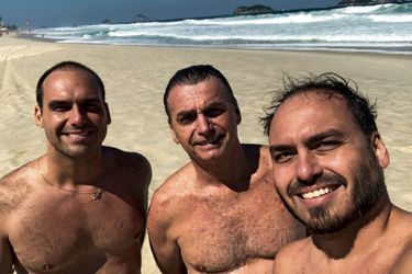 Août 2018. Au pied de sa maison sur la plage, dans le quartier de Barra à Rio, avec deux de ses fils. Eduardo (à g.), député fédéral de São Paulo depuis 2015, et Carlos (à dr.), conseiller municipal de Rio, élu à 17 ans.