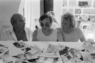 Charles Aznavour entouré d&#039;Eddie Barclay et Johnny Hallyday, dans la fameuse villa du producteur à Ramatuelle, près de Saint-Tropez, en août 1980.