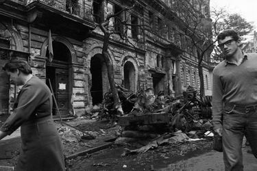 Quelques jours après l'invasion de la Tchécoslovaquie par les troupes du pacte de Varsovie, le reporter de Paris Match Jack Garofalo arpente les rue de Prague occupée. Ici dans la rue suite à une manifestation, les gravas d'un immeuble partiellement détruit jonchent le trottoir, ainsi que des arbres tombés et de véhicules blindés brulés.