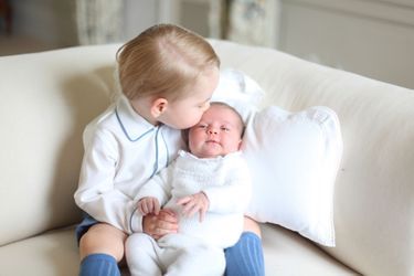 Le prince George tient dans ses bras la princesse Charlotte.