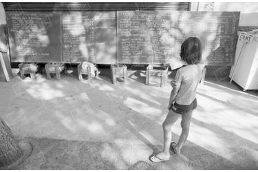 Deux jours après la catastrophe de Los Alfaques, un enfant regarde le tableau noir sur lequel est inscrite la liste des blessés et des hôpitaux vers lesquels ils ont été transférés.
