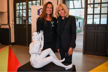 Laurence Jenkell et Brigitte Macron posent devant la sculpture de l&#039;artiste. 