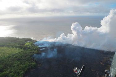 Sur ce cliché pris depuis un hélicoptère et publié par l&#039;US Geological Survey dimanche, une des coulées de lave du Kilauea entre dans l&#039;océan. La vapeur qui se dégage est corrosive et dangereuse.
