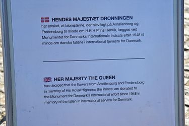 Texte indiquant que la reine Margrethe II de Danemark a fait placer les fleurs du prince Henrik au Kastellet à Copenhague