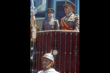 A la droite du Caudillo, qui l’a désigné comme son héritier, lors du défilé célébrant le 26e  anniversaire de la victoire des franquistes, en juillet 1965.
