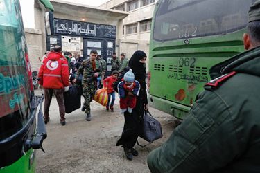 30 mars. Des réfugiés à la sortie du corridor de Wafidin. Un soldat syrien aide les familles à monter dans les bus.