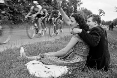 Le 41ème Tour de France, du 8 juillet au 1er août 1954 sur 23 étapes pour 4 656 km (premier départ donné à l'étranger : Amsterdam), avec la victoire de Louison Bobet : un couple d'amoureux salue le passage du peloton.