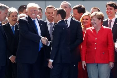 Au sommet de l&#039;Otan, poignée de mains entre Donald Trump et Emmanuel Macron, sous le regard amusé d&#039;Angela Merkel. 