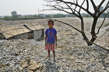 Un petit garçon devant une mer de déchets