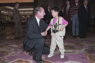 Lors d'un voyage à Shanghai, Jacques Chirac en admiration d'un petit garçon, petit reporter avec son appareil photo, mai 1997