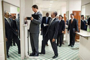 Taquin, Barack Obama appuie sur la balance où se pèse Marvin Nicholson, responsable de ses voyages, au Texas, en août 2010.