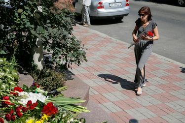 Une femme rend hommage aux victimes à l'ambassade de France à Kiev, en Ukraine