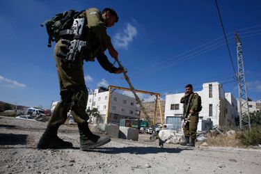 Des soldats israéliens posent des herses pour empêcher les véhicules palestiniens de passer en Israël