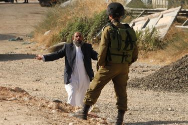 Un Palestinien négocie son passage avec un soldat Israélien