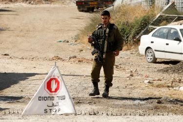 Un soldat israélien bloque le passage des Palestiniens