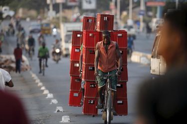 Un homme transporte des caisses sur son vélo