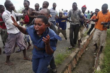 Un manifestant attrapant une policière accusée d'avoir tiré sur un manifestant en mai 2015 à Bujumbura