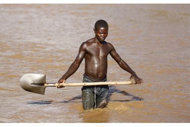 Un ouvrier récolte le sable des rives de la rivière Ntahangwa 