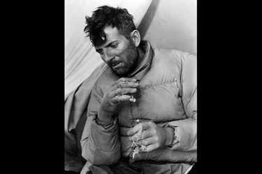 Le premier "huit mille" jamais vaincu dans l'histoire de l'humanité : Maurice Herzog sous une tente après sa victoire, visage épuisé, des lambeaux de peaux se détachant de ses mains gelées.