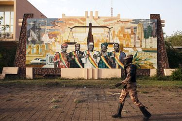 19 février, un gendarme passe devant une peinture murale à l&#039;extérieur du parlement de Bamako.