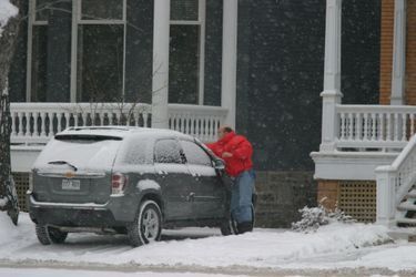 A Montréal, en décembre 2005, après sa condamnation. Alain Juppé dégivre le pare-brise de sa voiture