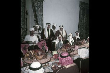 Le roi Saoud Ben Abdel Aziz déjeunant chez l'émir de Riyad avec d'autres invités à qui l'on sert des moutons entiers