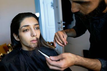 Un ami maquilleur pose une barbe sur le visage triste de Zeinab : pas drôle de devoir dissimuler sa féminité.