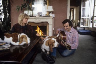 Dick Rivers avec sa compagne Babette et leurs deux chiens, les bassets Virgule et Goofy, dans leur appartement de Montmartre, en juillet 1986.