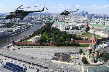 Des hélicoptères militaires Mi-8 volent en groupe au dessus de la place rouge.