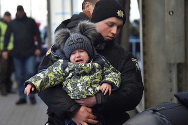 Un policier tient un enfant dans ses bras, le 15 mars 2022 à Lviv.