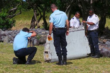 Des gendarmes inspectent le bout d&#039;aîle retrouvé à La Réunion.