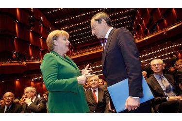 <br />
La chancelière allemande Angela Merkel et l’Italien Mario Draghi, le 19 octobre 2011  à Francfort, lors de la cérémonie d’adieu de Jean-Claude Trichet (au centre),  son prédécesseur à la tête de la Banque centrale européenne.