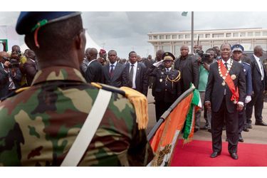 <br />
Alassane Ouattara, assisté de son aide de camp (arrière-plan, en uniforme bleu)  et de Soumaïla Bakayoko, l’ancien chef des forces rebelles (à g.), passe en  revue les troupes qui lui font allégeance en lui présentant le drapeau national. 
