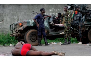 <br />
A Abidjan, des soldats loyaux au président Ouattara s&#039;arrêtent devant un homme blessé, étendu sur la route.