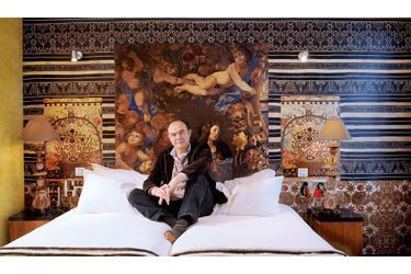 <br />
Christian Lacroix pose ici dans la chambre « Les anges » qui évoluent dans un décor de brocart brodé. 