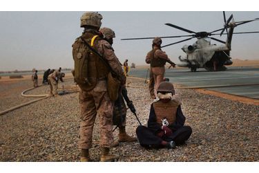 <br />
Sur la base aérienne de Dwyer, deux marines surveillent un prisonnier taliban qu’ils accompagnent pour un interrogatoire. 