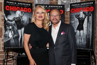 Pamela Anderson et le producteur Barry Weissler posent devant les posters de «Chicago», à New York, le 23 mars 2022.